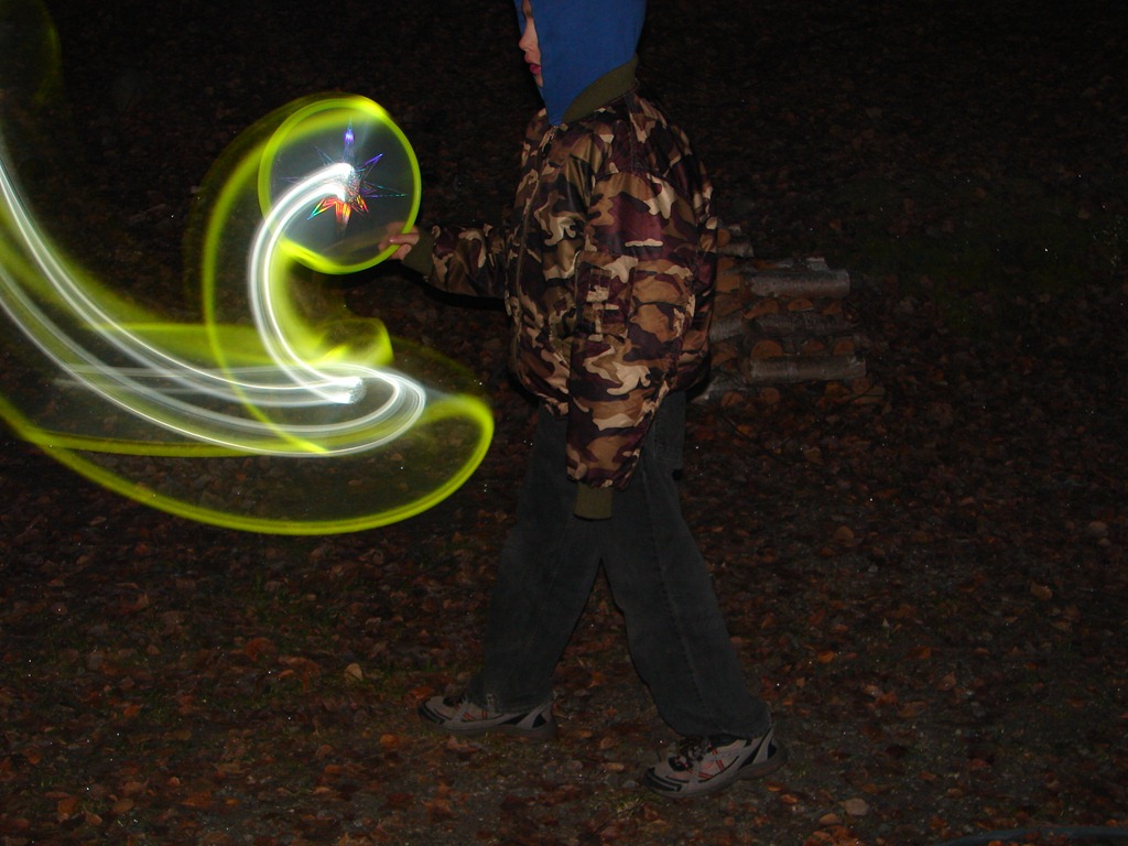 Boy swirling the Aerobie Skylight Disc at night