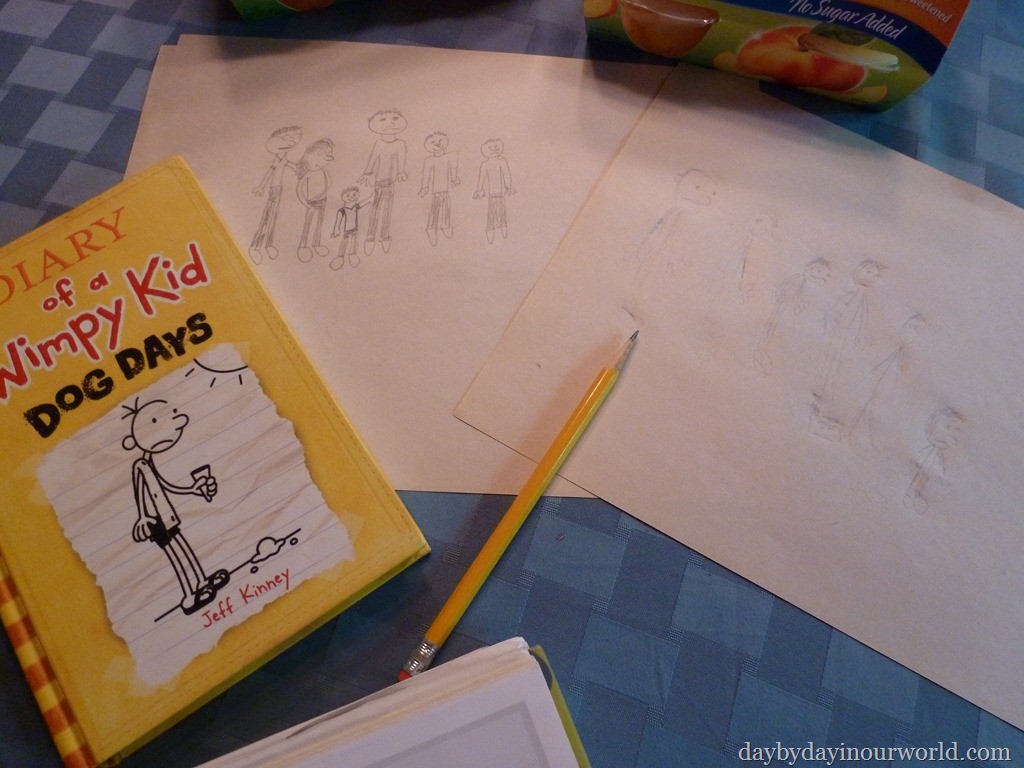 Diary of a Whimpy kid book sits on table by a spread of pages with drawings on them.
