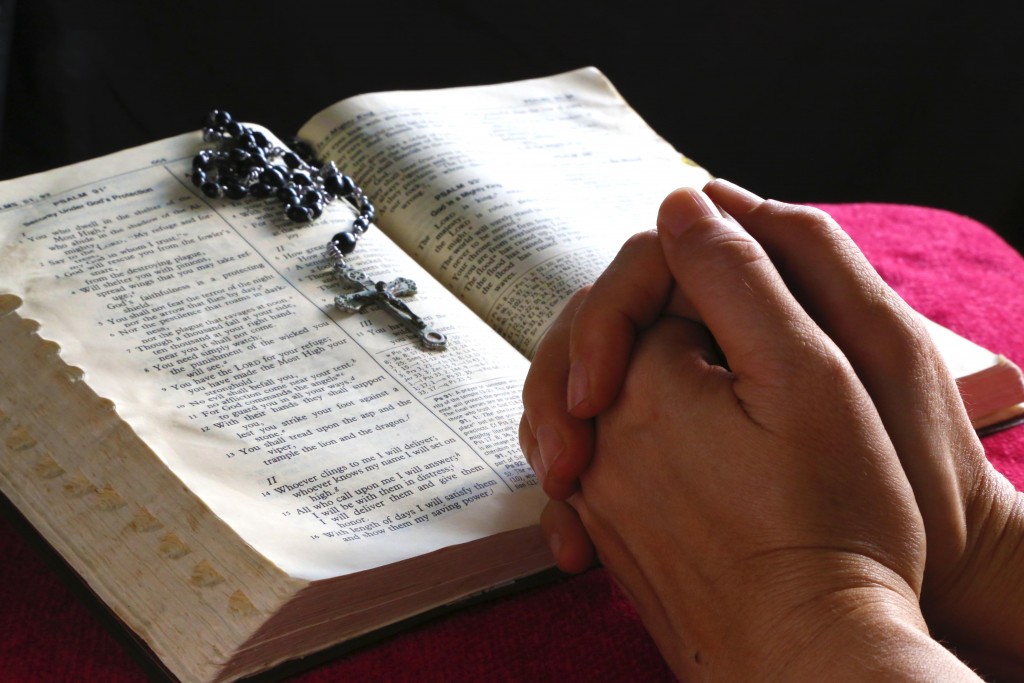Praying with Bible and Rosary