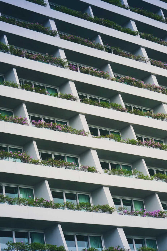 Tall building with balcony gardens along the rails