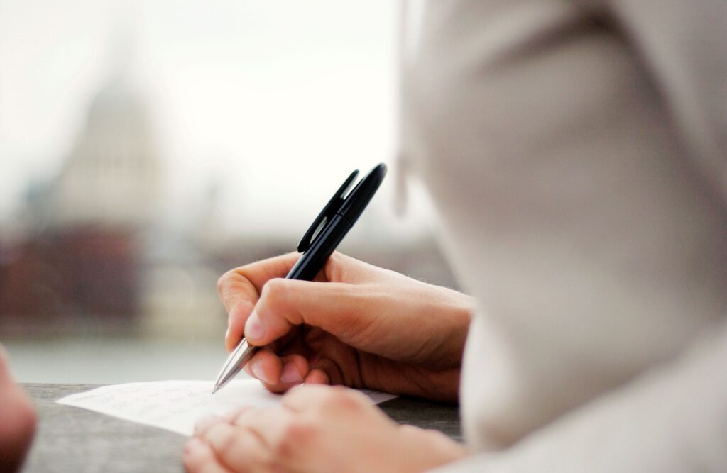 woman writes with pen on paper