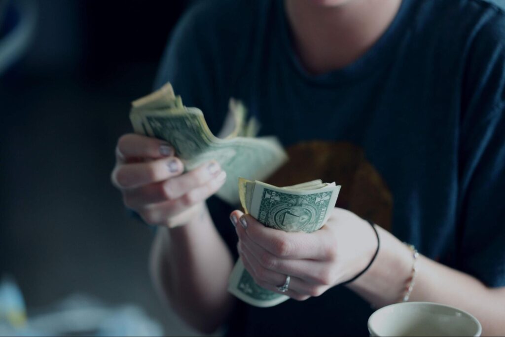 woman fanning $100 bills