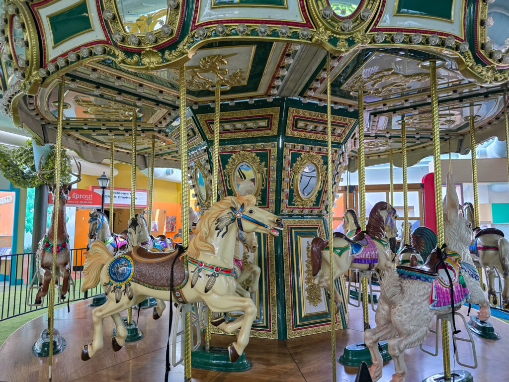 Ornately decorated carousel with colorful horses inside the Children’s Museum of Richmond.